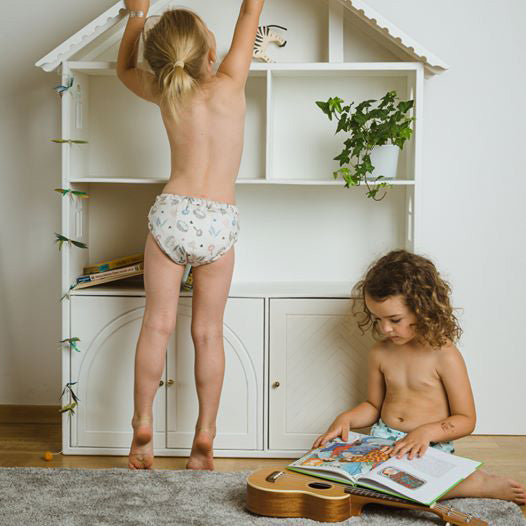 Δυο παιδάκια που φοράνε Βρακάκι Εκμάθησης Μωρού Popolini το ένα διαβάζει βιβλίο